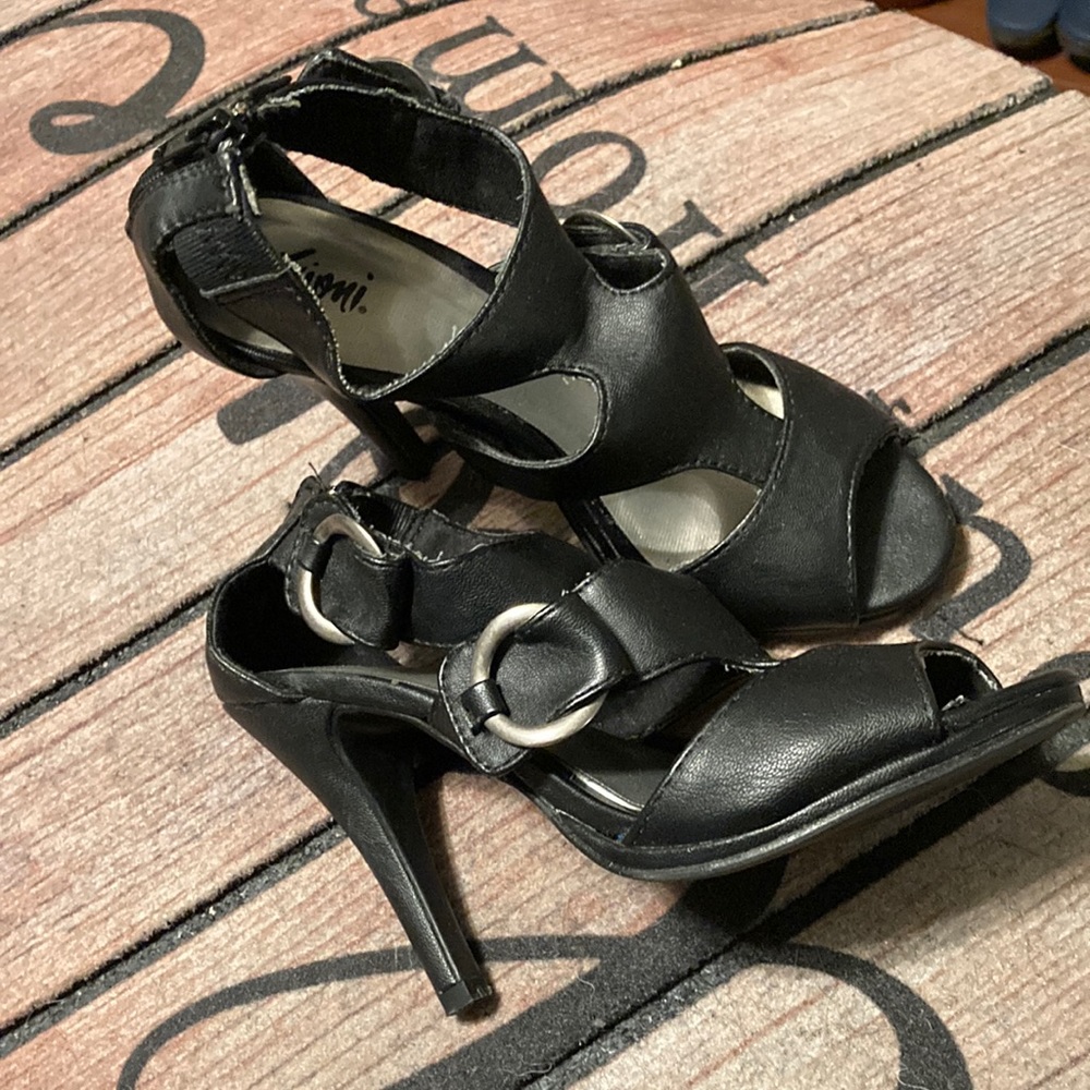 Fioni Black heels with zipper on the back and silver rings on the side.